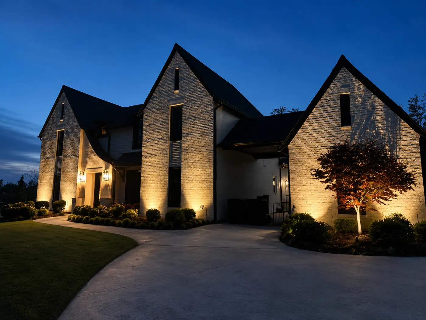 Stone European home uplighting at dusk Alabama